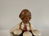 a figurine of a man sitting on top of a pile of eggs