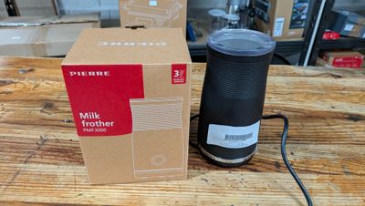 une brique de lait posée à côté d'une tasse de café sur une table