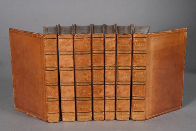 several old books are stacked on top of each other on a table