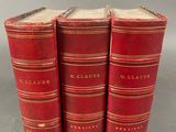 trois livres rouges superposés sur une table