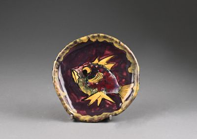 an image of a red and gold plate with a bird on it