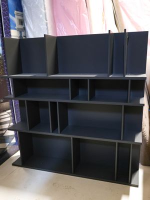 a black book shelf that is in the middle of a room
