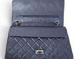 the back of a blue purse with a chain hanging from it ' s side