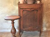 a small table with plates and cups on it next to a cabinet