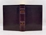 an old book with a leather cover sitting on top of a white table