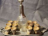 a silver tray with cups and a decanter on it