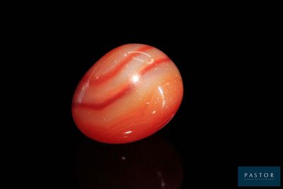 une bille orange et blanche posée sur une surface noire