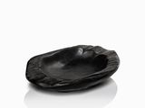 a black bowl that is sitting on a white surface