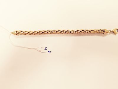 a close up of a gold bracelet with a chain attached to it