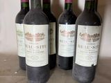 three bottles of red wine are lined up on a counter