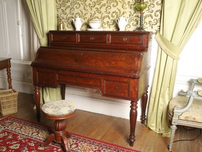 a small desk with a stool in the corner of the room