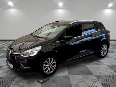 La voiture noire est garée sur un sol en carrelage à damier.