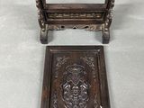 two pieces of wood with carvings on them sitting on a table