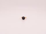 un seul anneau de pierre noire sur une surface blanche