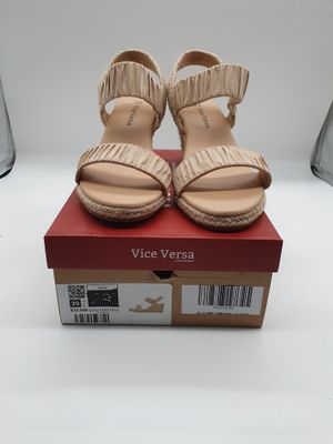 La boîte à chaussures est ouverte et contient une paire de sandales.