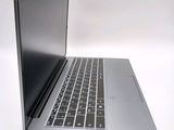 a silver laptop with a black keyboard on a white surface