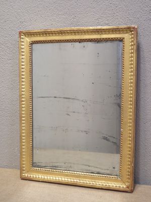 a picture of a gold framed mirror sitting on a table