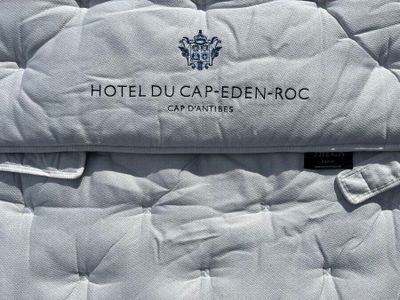 a close up picture of a hotel bed with a logo on it
