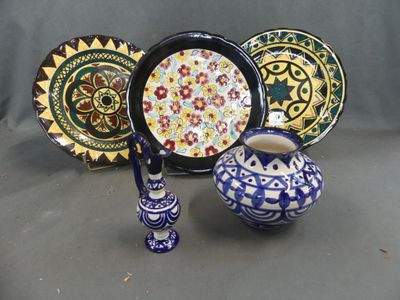 a lot of different plates and vases on the table