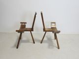 two wooden chairs sitting next to each other in a room