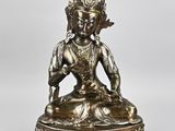 a silver statue of a person sitting on a lotus