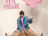 un homme assis par terre, tenant un bouquet de ballons