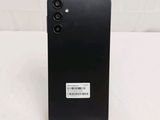 a close up of the back of a black phone on a white surface
