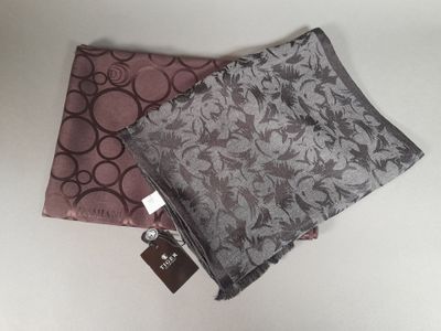 two pieces of fabric are laying on a table with a tag