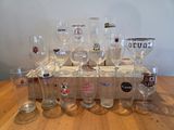 bottles and glasses are lined up on a wooden tray on a table