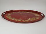 a red and gold tray with a floral design on it