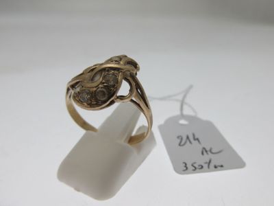 une image d'une bague en or sur une surface blanche avec une étiquette de prix