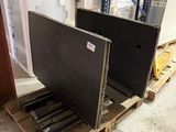 two televisions sitting on a pallet in a warehouse