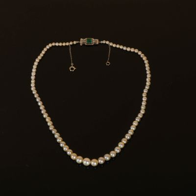 un ensemble composé d'un collier et de boucles d'oreilles en perles blanches sur fond noir