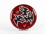a red plate with black and white designs on it