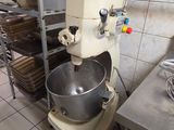 un mixeur dans une cuisine où le plan de travail est encombré de nombreuses casseroles et poêles