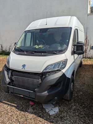 une camionnette blanche garée à côté d'un immeuble