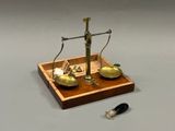 une image représentant une balance sur laquelle sont posés une cuillère et un repose-cuillère