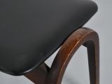 the back of a black chair with a wooden frame and a leather seat
