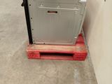 a metal box sitting on top of a pallet in a warehouse