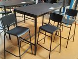 une table et des chaises dans une pièce où est accroché un sac à dos au mur