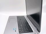 a silver laptop with a black keyboard on a white surface