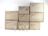 Plusieurs verres à vin vides sont posés devant une pile de cartons