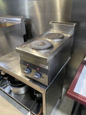 stainless steel counter top with two burners and a pot on it