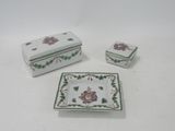 three small dishes and a box on a white table