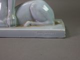 a figurine of a cat sitting on a book