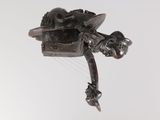 une sculpture métallique représentant un oiseau en plein vol sur fond blanc