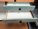 une commode sur laquelle se trouvent deux tiroirs