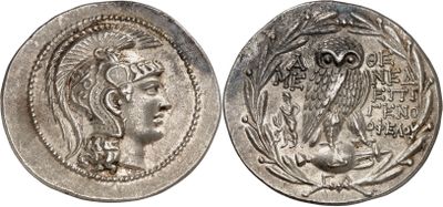 a silver coin with an image of a woman and an owl on it