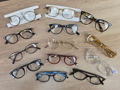 several pairs of eyeglasses sitting on a wooden table