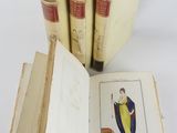 several books are stacked on top of each other on a white surface